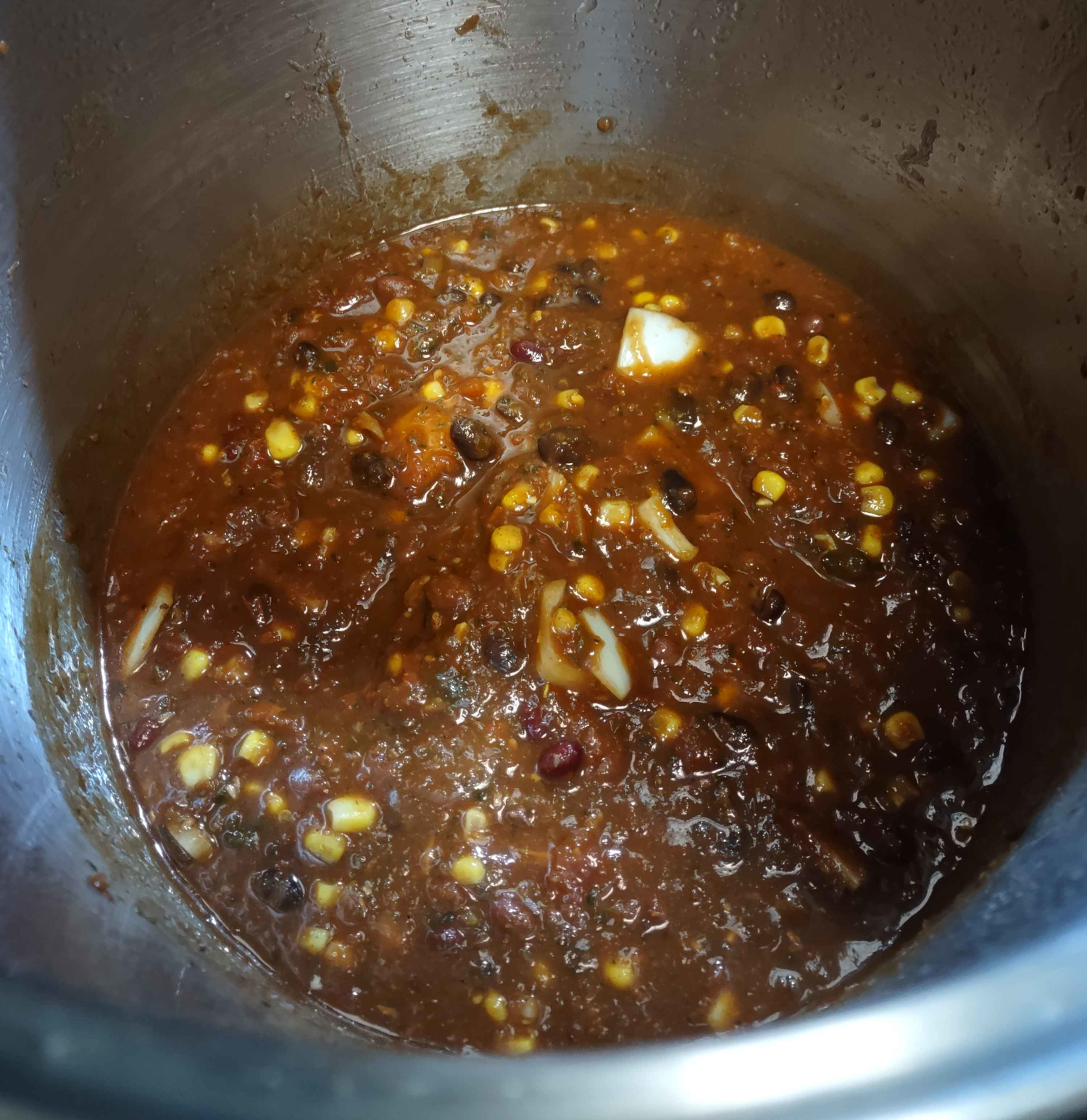 i then added a 28 oz can of crushed tomatoes (i normally use diced but i didn't have any on hand), a diced sweet onion, and a 14 oz can each of corn, black beans, red beans, and dark red kidney beans. it's now on a low simmer on my stove